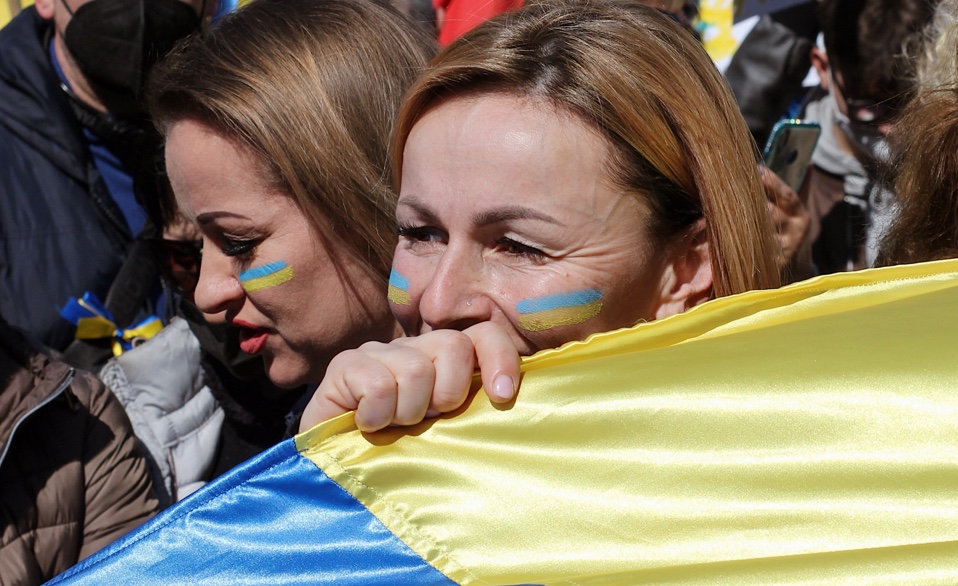 Women with ukrainian flag demonstrating against the war showing solidarity